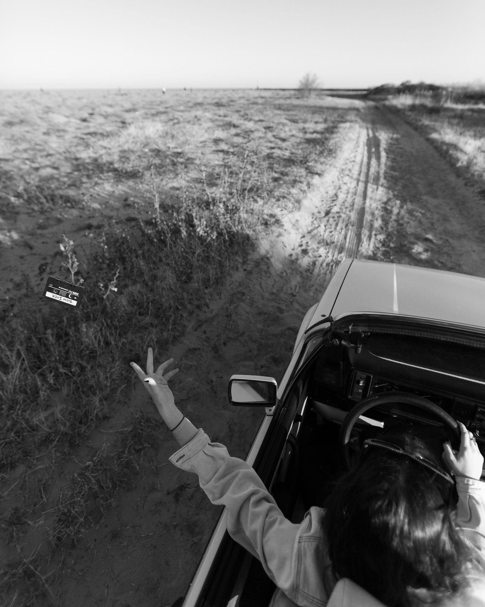VW convertible driving along a sandy path beside the beach in Burriana