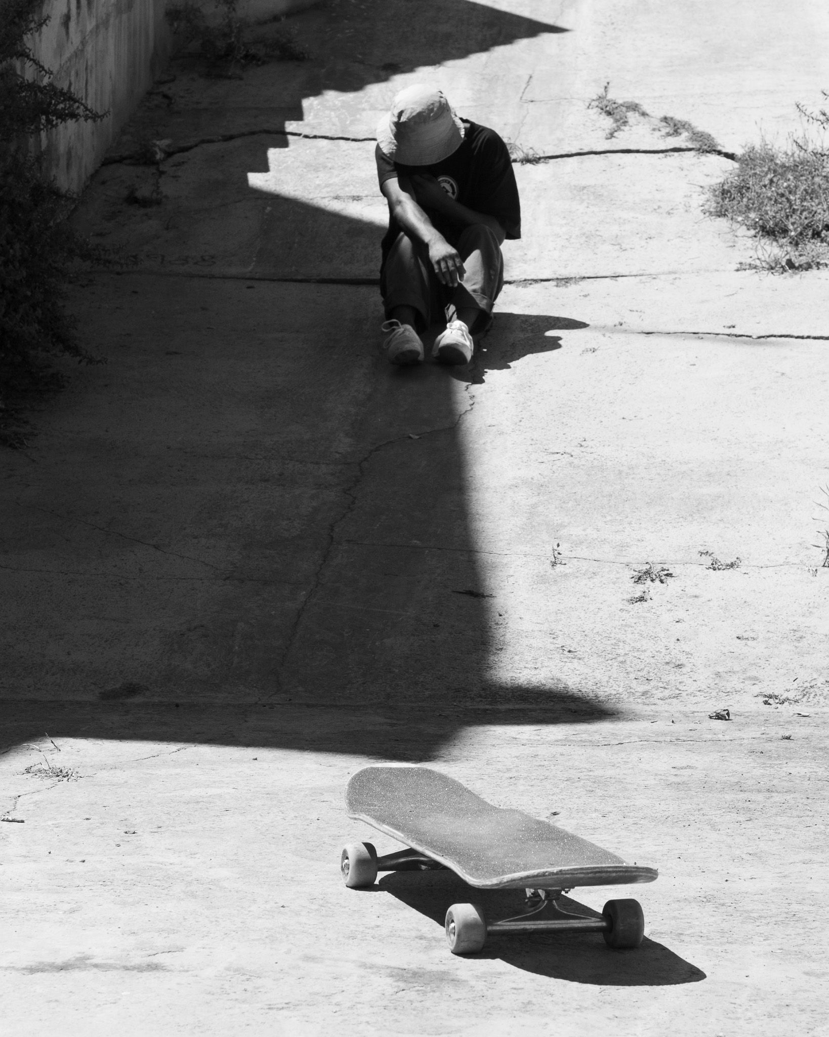 Skater resting in the shade of a concrete ramp in Castellon