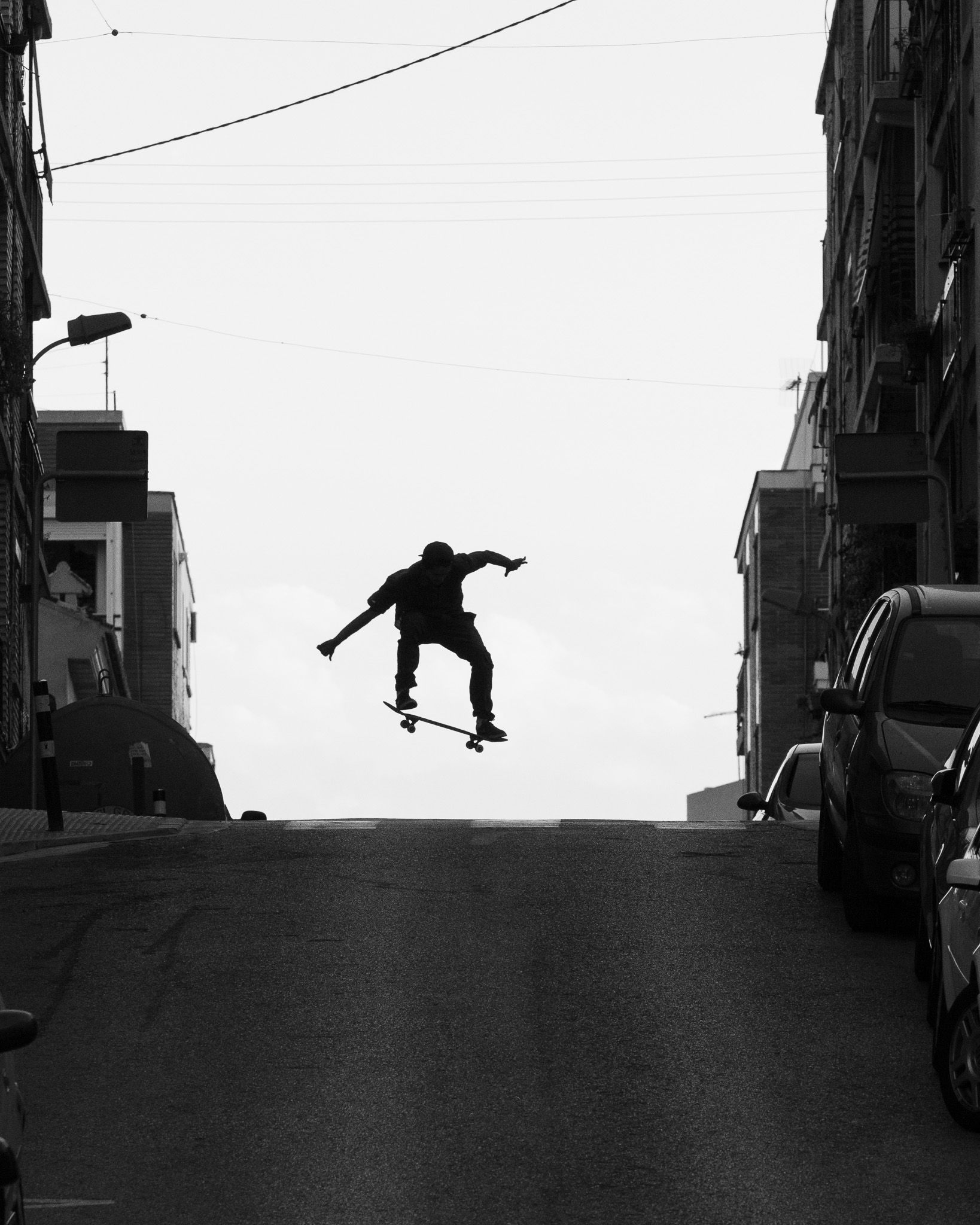 Silhouette of a skater jumping above a steep street in Burjassot, Valencia