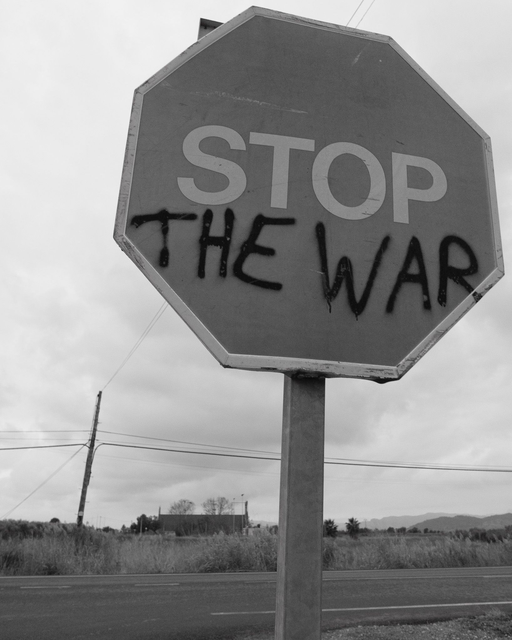 STOP sign altered with the phrase THE WAR on a rural road in Valencia