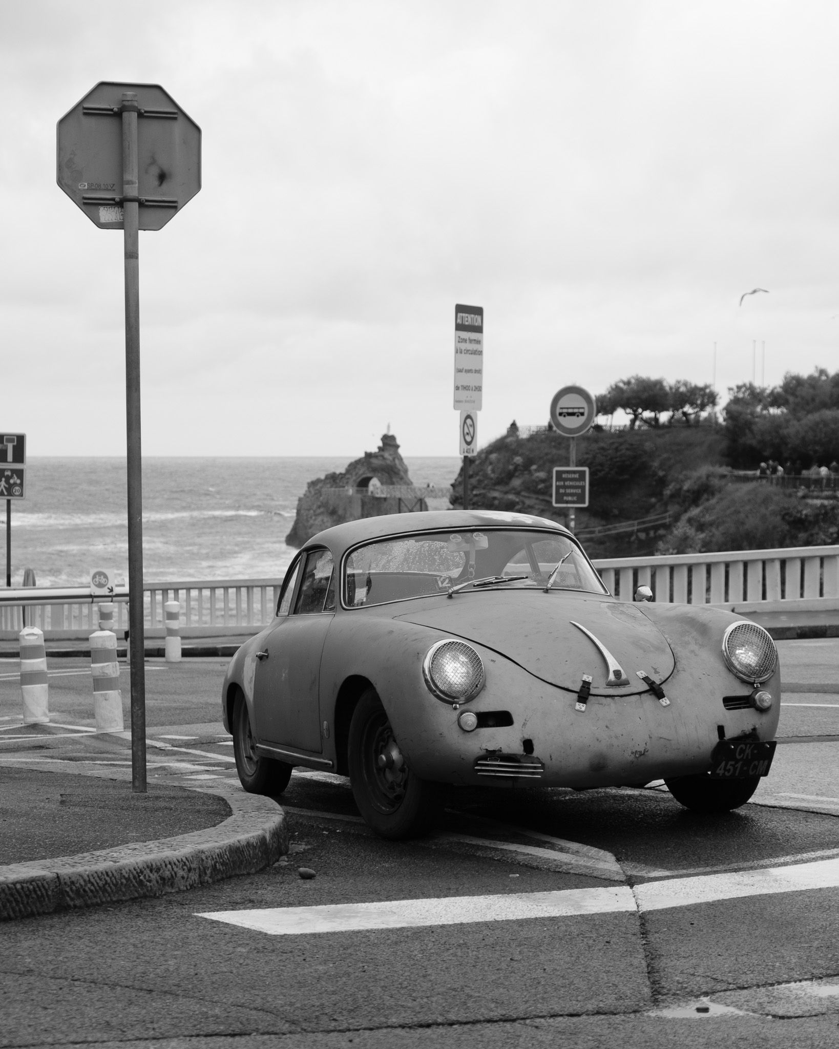 Weathered Porsche 356 beside the Biarritz cliffs with a seagull in flight