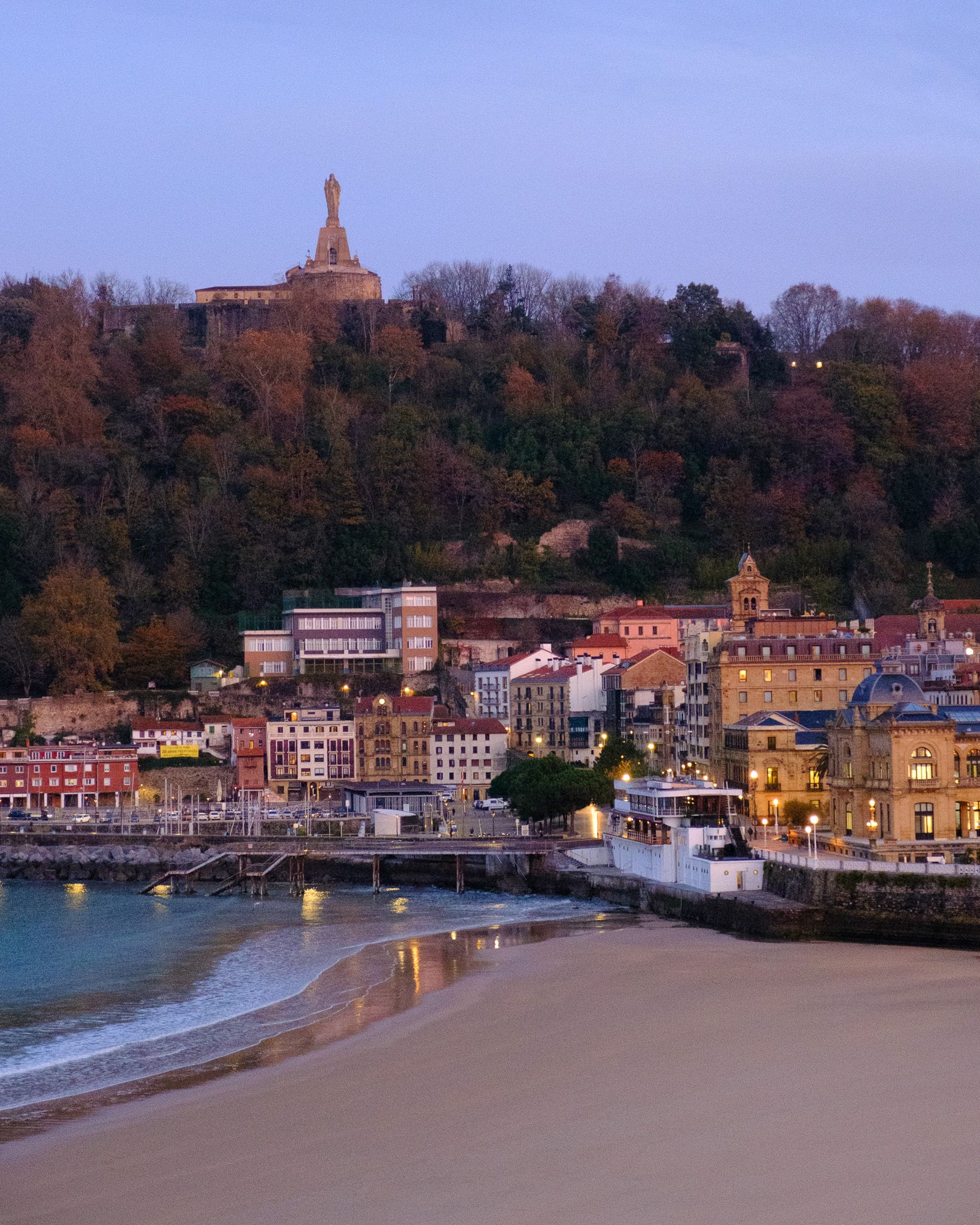 La Concha bay at sunrise with Mount Urgull and wet sand in San Sebastian